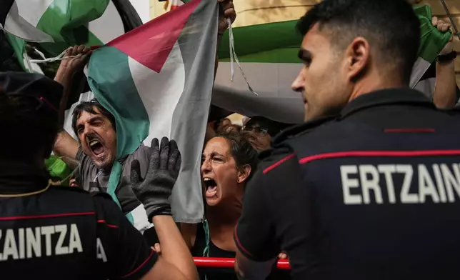 People hold Palestinian flags as they try to disrupt the eleventh stage of the Spanish Vuelta cycling race, from Bilbao to Bilbao, Spain, Wednesday, Sept. 3, 2025. (AP Photo/Miguel Oses)