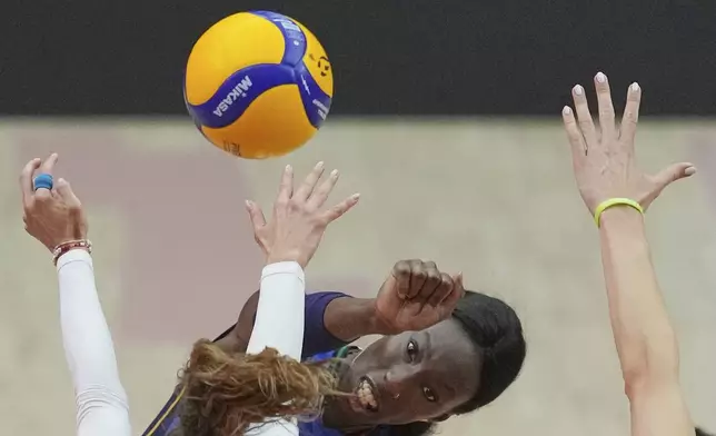 Italy's Benedetta Maria Sartori, center, spikes the ball against Poland's Paulina Damaske during the FIVB Women's Volleyball World Championship 2025 quarter final match between Italy and Poland at Indoor stadium Huamark in Bangkok, Thailand, Wednesday, Sept. 3, 2025. (AP Photo/Sakchai Lalit)