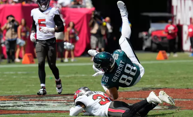 Philadelphia Eagles tight end Dallas Goedert (88) is taken down by Tampa Bay Buccaneers safety Antoine Winfield Jr. (31) after a catch during the first half of an NFL football game Sunday, Sept. 28, 2025, in Tampa, Fla. (AP Photo/Chris O'Meara)