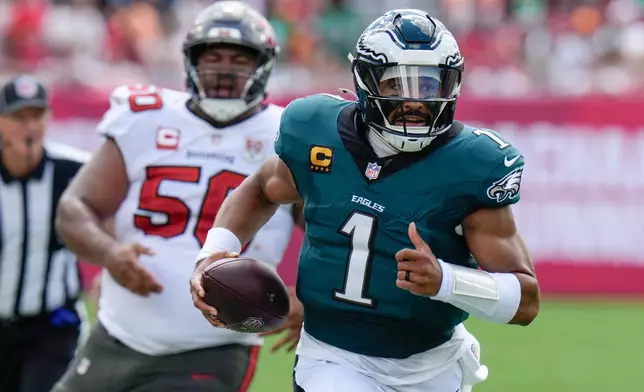 Philadelphia Eagles quarterback Jalen Hurts (1) runs the ball for a first down during the first half of an NFL football game against the Tampa Bay Buccaneers, Sunday, Sept. 28, 2025, in Tampa, Fla. (AP Photo/Chris O'Meara)