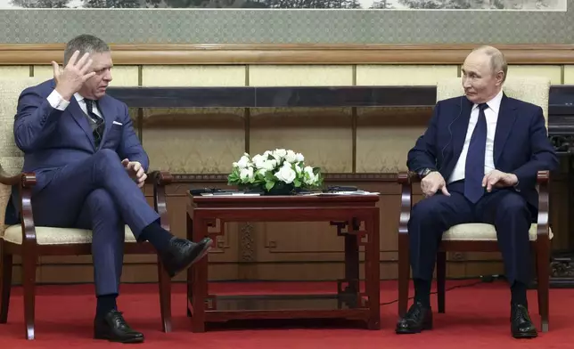 Slovak Prime Minister Robert Fico, left, gestures speaking to Russian President Vladimir Putin during their meeting at the Diaoyutai State Guesthouse in Beijing, China, Tuesday, Sept. 2, 2025. (Vladimir Smirnov, Sputnik, Kremlin Pool Photo via AP)