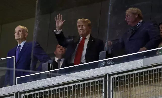 President Donald Trump, center, gestures next to New York Yankees president Randy Levine, front right, during the seventh inning of a baseball game against the Detroit Tigers, Thursday, Sept. 11, 2025, in New York. (AP Photo/Adam Hunger)