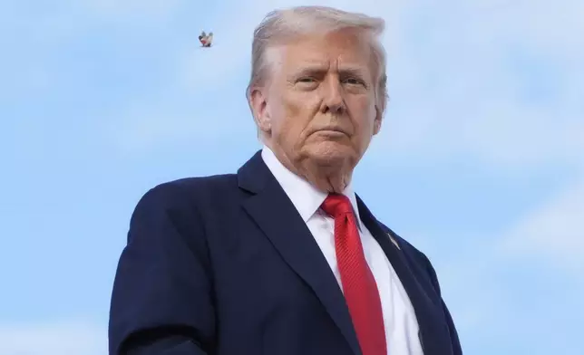 A spotted lanternfly flies past President Donald Trump as he boards Air Force One, Thursday, Sept. 11, 2025, at Joint Base Andrews, Md., to travel to New York. (AP Photo/Alex Brandon)