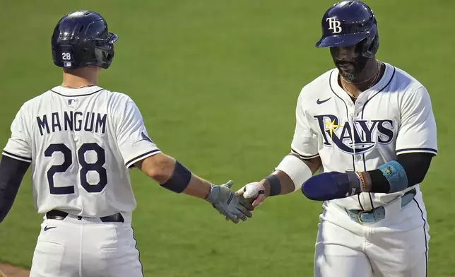 Tampa Bay Rays' Yandy Díaz celebrates with Jake Mangum (28) after scoring on an RBI single by Junior Caminero off Seattle Mariners pitcher Bryan Woo during the first inning of a baseball game Tuesday, Sept. 2, 2025, in Tampa, Fla. (AP Photo/Chris O'Meara)