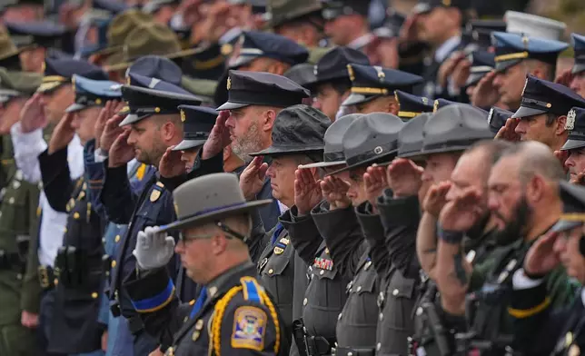 Officers salute during a procession for slain Northern York County Regional Police detectives Cody Michael Becker, Mark Edward Baker and Isaiah Emenheiser, Thursday, Sept. 25, 2025, in Red Lion, Pa. (AP Photo/Matt Rourke)