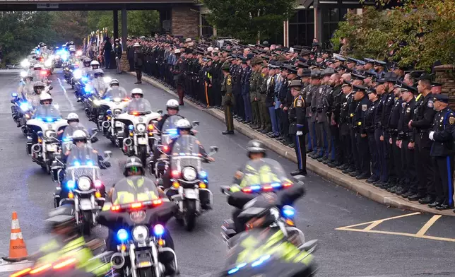 Officers watch a procession for slain Northern York County Regional Police detectives Cody Michael Becker, Mark Edward Baker and Isaiah Emenheiser, Thursday, Sept. 25, 2025, in Red Lion, Pa. (AP Photo/Matt Rourke)