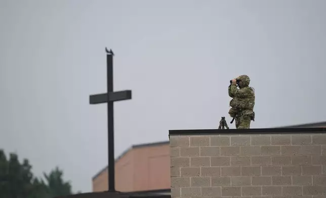 An officer stands watch ahead of funeral services for slain Northern York County Regional Police detectives Cody Michael Becker, Mark Edward Baker and Isaiah Emenheiser, Thursday, Sept. 25, 2025, in Red Lion, Pa. (AP Photo/Matt Rourke)