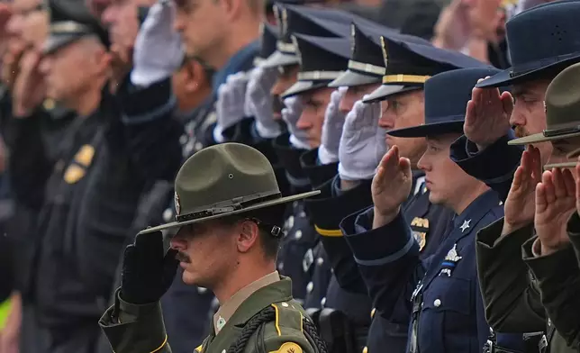 Officers salute during a procession for slain Northern York County Regional Police detectives Cody Michael Becker, Mark Edward Baker and Isaiah Emenheiser, Thursday, Sept. 25, 2025, in Red Lion, Pa. (AP Photo/Matt Rourke)