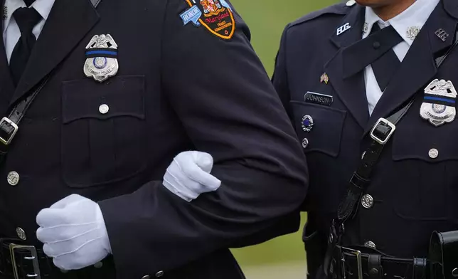 Officers stand arm and arm during funeral services for slain Northern York County Regional Police detectives Cody Michael Becker, Mark Edward Baker and Isaiah Emenheiser, Thursday, Sept. 25, 2025, in Red Lion, Pa. (AP Photo/Matt Rourke)