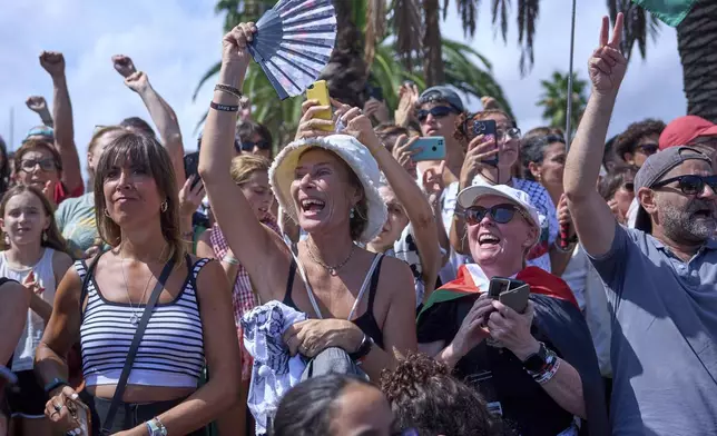 People shout slogans as they bid farewell to activists setting sail on their boats to join a civilian flotilla bound for Gaza, with the aim of breaking the Israeli blockade and delivering humanitarian aid, in Barcelona, Spain, on Sunday, August 31, 2025. (AP Photo/Emilio Morenatti)
