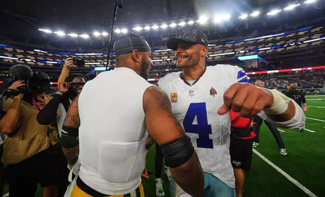 Green Bay Packers defensive end Micah Parsons, left, and Dallas Cowboys quarterback Dak Prescott (4) greet each other after their team's overtime NFL football game which ended in a tie Sunday, Sept. 28, 2025, in Arlington, Texas. (AP Photo/Julio Cortez)