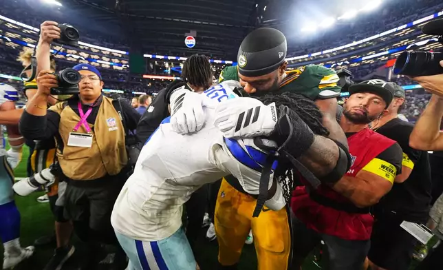 Dallas Cowboys cornerback Trevon Diggs, left, and Green Bay Packers' Micah Parsons, right, joke with each other after an NFL football game Sunday, Sept. 28, 2025, in Arlington, Texas. (AP Photo/Julio Cortez)