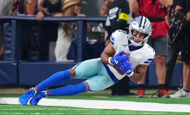Dallas Cowboys wide receiver Jalen Tolbert catches a long pass along the sideline in overtime of an NFL football game against the Green Bay Packers Sunday, Sept. 28, 2025, in Arlington, Texas. (AP Photo/Julio Cortez)
