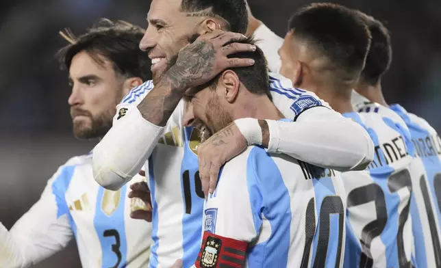 Argentina's Nicolas Otamendi congratulates Lionel Messi after he scored his side's third goal against Venezuela during a World Cup 2026 qualifying soccer match at the Monumental stadium in Buenos Aires, Argentina, Thursday, Sept. 4, 2025. (AP Photo/Gustavo Garello)