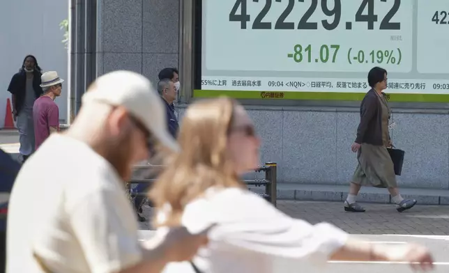 People walk in front of an electronic stock board showing Japan's Nikkei index at a securities firm Wednesday, Sept. 3, 2025, in Tokyo. (AP Photo/Eugene Hoshiko)