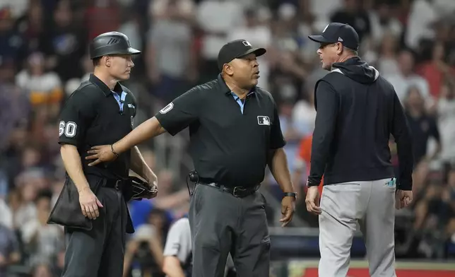 New York Yankees manager Aaron Boone, right, has words with home plate umpire Brian Walsh, left, as umpire Adrian Johnson, center, stands between them after Boone was ejected during the eighth inning of a baseball game Wednesday, Sept. 3, 2025, in Houston. (AP Photo/Karen Warren)