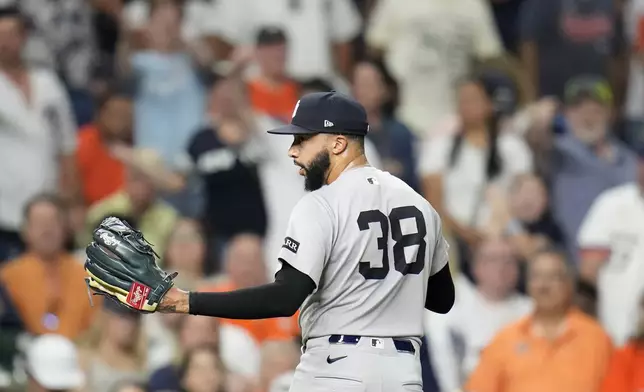 New York Yankees relief pitcher Devin Williams (38) exchanges words with home plate umpire Brian Walsh as he walked back to the dugout after giving up a run walking Houston Astros' Taylor Trammell with the bases loaded during the eighth inning of a baseball game Wednesday, Sept. 3, 2025, in Houston. (AP Photo/Karen Warren)