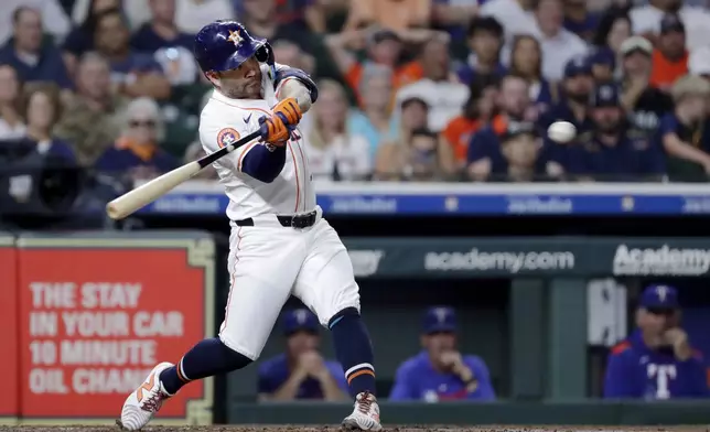 Houston Astros' Jose Altuve swings on his two run home run against the Texas Rangers during the third inning of a baseball game Wednesday, Sept. 17, 2025, in Houston. (AP Photo/Michael Wyke)