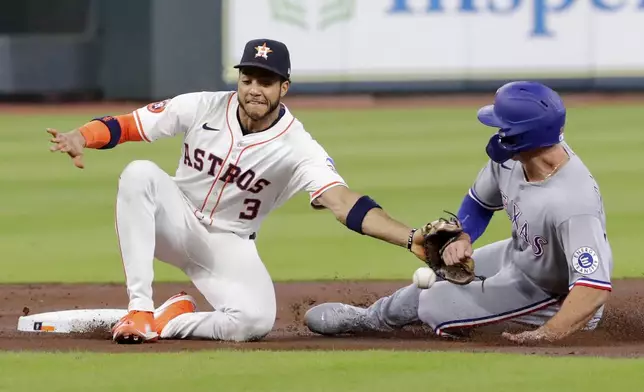 Houston Astros shortstop Jeremy Pena (3) misses the catch as Texas Rangers' Wyatt Langford, right, safely steals second base during the first inning of a baseball game Wednesday, Sept. 17, 2025, in Houston. (AP Photo/Michael Wyke)