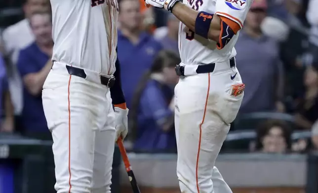Houston Astros' Carlos Correa, left, and Jeremy Pena, right, celebrate the solo home run by Pena against the Texas Rangers during the fifth inning of a baseball game Wednesday, Sept. 17, 2025, in Houston. (AP Photo/Michael Wyke)