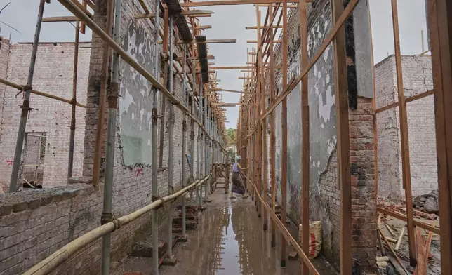 Laborers work at a building in the Mandalay University compound that was damaged in the March 28 earthquake in Mandalay, Myanmar, Wednesday, Aug. 27, 2025. (AP Photo/Aung Shine Oo)