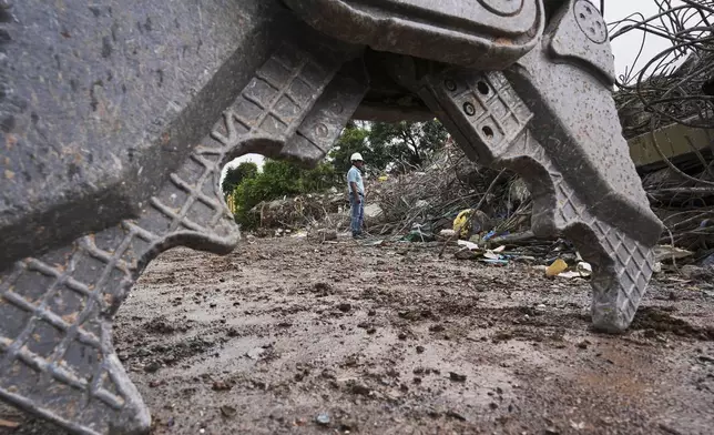 A family member watches recovery efforts at the site of a 10-story condo that collapsed during the March 28 earthquake, in Mandalay, Myanmar, Aug. 27, 2025. (AP Photo/Aung Shine Oo)