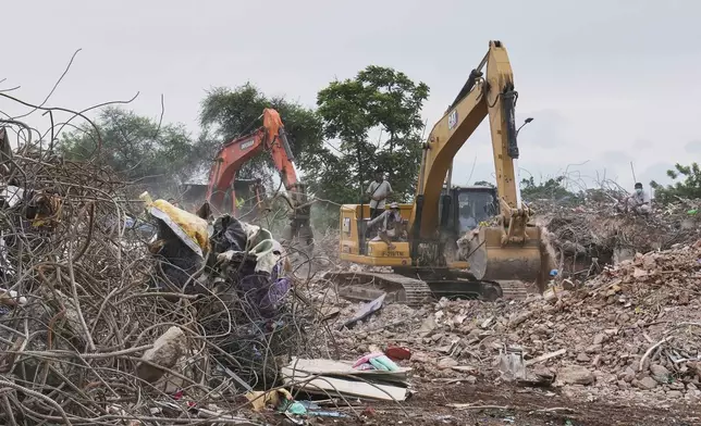 Family members watch recovery efforts at the site of a 10-story condo that collapsed during the March 28 earthquake, in Mandalay, Myanmar, Aug. 27, 2025. (AP Photo/Aung Shine Oo)