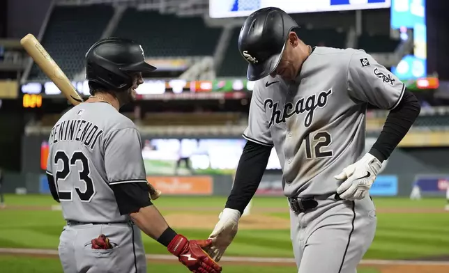 Chicago White Sox's Colson Montgomery (12) celebrates with Andrew Benintendi (23) after hitting a 2-run home run during the ninth inning of a baseball game against the Minnesota Twins Thursday, Sept. 4, 2025, in Minneapolis. (AP Photo/Abbie Parr)