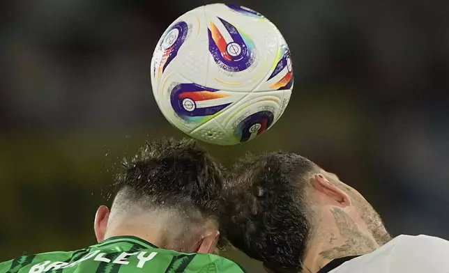 Northern Ireland's Conor Bradley, left, and Germany's David Raum reach for a header during the FIFA World Cup Group A qualifying soccer match between Germany and Northern Ireland at RheinEnergieStadion stadium in Cologne, Germany, Sunday, Sept. 7, 2025 (AP Photo/Martin Meissner)