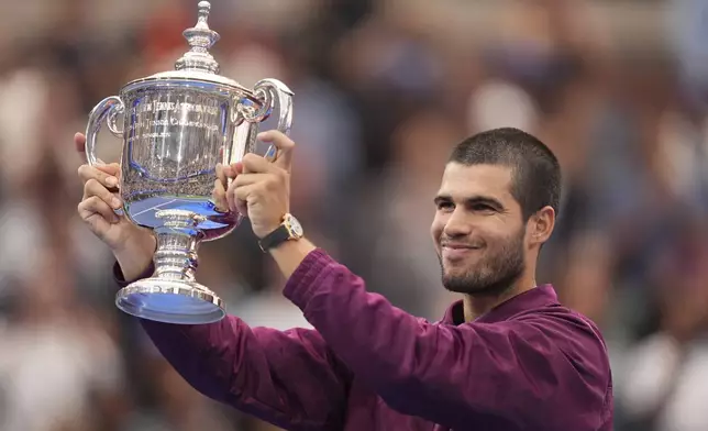 Carlos Alcaraz, of Spain, lifts the championship trophy after defeating Jannik Sinner, of Italy, in the men's singles final of the U.S. Open tennis championships, Sunday, Sept. 7, 2025, in New York. (AP Photo/Seth Wenig)
