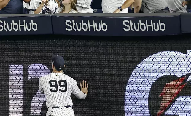New York Yankees outfielder Aaron Judge watches as fans try to catch a home run ball hit by Toronto Blue Jays' Vladimir Guerrero Jr. during the fifth inning of a baseball game Friday, Sept. 5, 2025, in New York. (AP Photo/Adam Hunger)