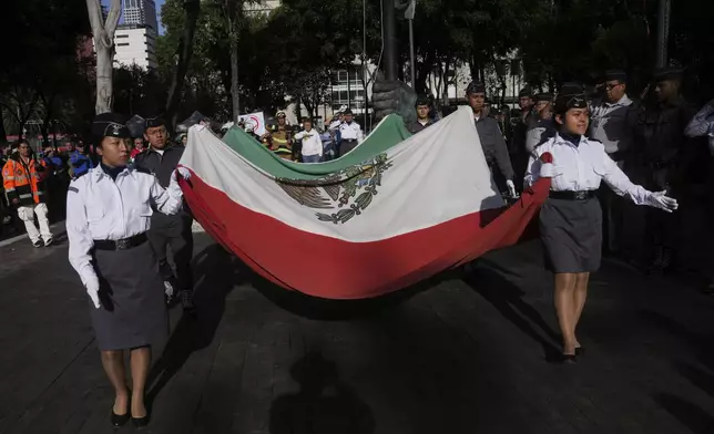 Military school cadets carry a Mexican flag during a ceremony marking the 1985 earthquake's 40th anniversary in Mexico City, Friday, Sept. 19, 2025. (AP Photo/Marco Ugarte)