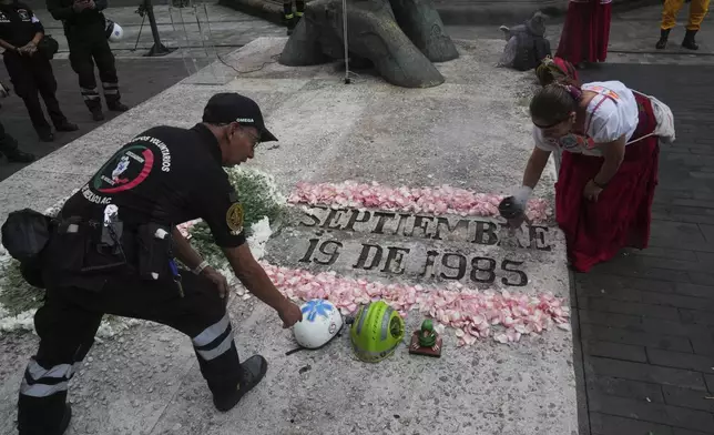 Francisco Camacho, of the Topos volunteer rescue workers brigade, left, and an Indigenous woman, attend a ceremony marking the 1985 earthquake's 40th anniversary in Mexico City, Friday, Sept. 19, 2025. (AP Photo/Marco Ugarte)