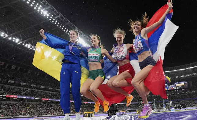 Gold medalist Australia's Nicola Olyslagers, second left, celebrates with silver medalist Poland's Maria Żodzik, second right, and joint bronze medal winners Ukraine's Yaroslava Mahuchikh, left, and Serbia's Angelina Topic, right, following the women's high jump final at the World Athletics Championships in Tokyo, Sunday, Sept. 21, 2025. (AP Photo/Ashley Landis)