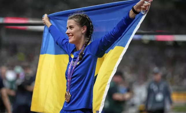 Ukraine's Yaroslava Mahuchikh celebrates taking the bronze in the women's high jump final at the World Athletics Championships in Tokyo, Sunday, Sept. 21, 2025. (AP Photo/Louise Delmotte)