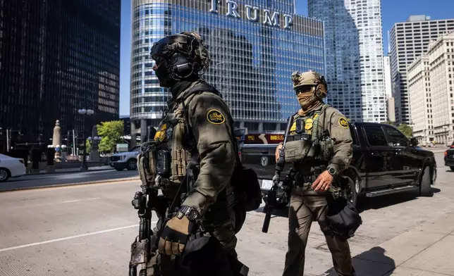 Federal agents from U.S. Immigration and Customs Enforcement and U.S. Customs and Border Protection walk along West Wacker Drive in the Loop, Sunday, Sept. 28, 2025, in Chicago. (Ashlee Rezin/Chicago Sun-Times via AP)