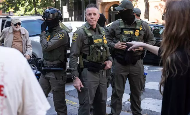 Pedestrians yell at Greg Bovino, the chief patrol agent for the U.S. Border Patrol El Centro sector, as he stands with federal immigration agents on North Clark Street at West Oak Street in the River North neighborhood, Sunday, Sept. 28, 2025, in Chicago. (Ashlee Rezin/Chicago Sun-Times via AP)