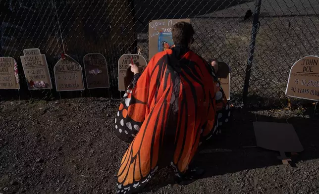 A protester puts out plaques for a memorial outside a U.S. Immigration and Customs Enforcement facility on Sunday, Sept. 28, 2025, in Portland, Ore. (AP Photo/Jenny Kane)