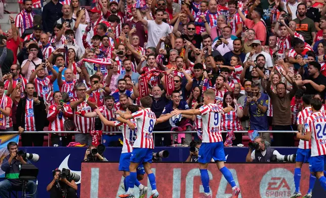 Atletico Madrid players celebrate their side's third goal during the Spanish La Liga soccer match between Atletico Madrid and Real Madrid at Metropolitano stadium, in Madrid, Spain, Saturday, Sept. 27, 2025. (AP Photo/Manu Fernandez)