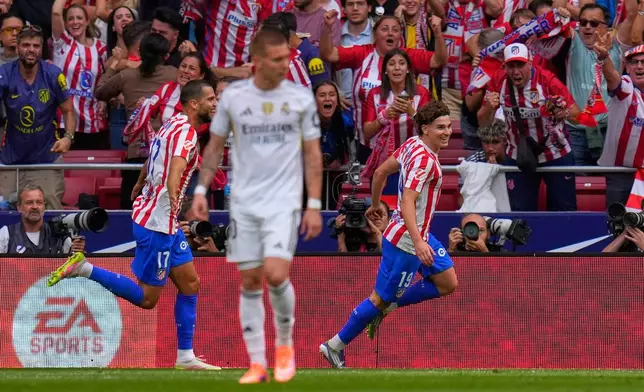 Atletico Madrid's Julian Alvarez, right, celebrates after scoring his side's fourth goal during the Spanish La Liga soccer match between Atletico Madrid and Real Madrid at Metropolitano stadium, in Madrid, Spain, Saturday, Sept. 27, 2025. (AP Photo/Manu Fernandez)
