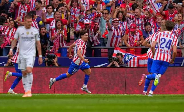 Atletico Madrid's Julian Alvarez celebrates after scoring his side's fourth goal during the Spanish La Liga soccer match between Atletico Madrid and Real Madrid at Metropolitano stadium, in Madrid, Spain, Saturday, Sept. 27, 2025. (AP Photo/Manu Fernandez)