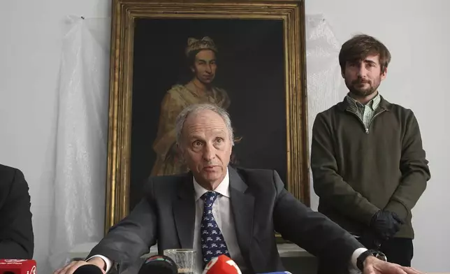 Prosecutor Daniel Adlers gives a press conference in front of Giuseppe Ghislandi's 18th-century painting "Portrait of a Lady," reportedly stolen by a Nazi officer during World War II and discovered in the home of his daughter after appearing in a real estate listing, in Mar del Plata, Argentina, Wednesday, Sept. 3, 2025. (AP Photo/Christian Heit)