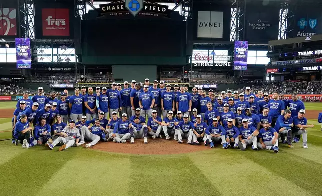 Los Angeles Dodgers players and coaches after the Dodgers clinched the National League West title against the Arizona Diamondbacks during a baseball game at Chase Field Thursday, Sept. 25, 2025, in Phoenix. (AP Photo/Darryl Webb)