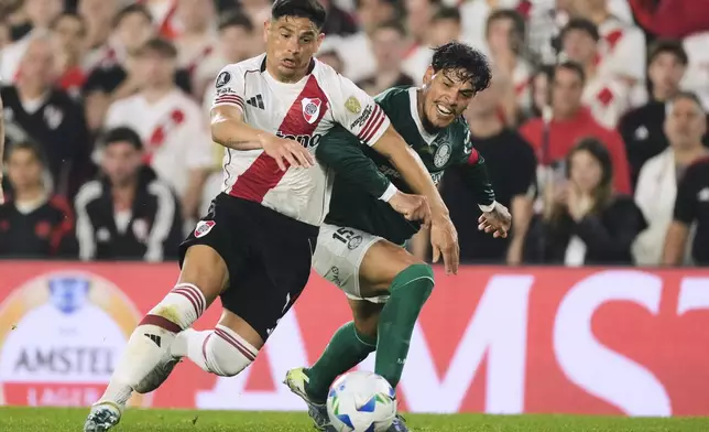 Maximiliano Salas of Argentina's River Plate, left, and Gustavo Gomez of Brazil's Palmeiras battle for the ball during a Copa Libertadores quarterfinal soccer match at the Monumental stadium in Buenos Aires, Argentina, Wednesday, Sept. 17, 2025. (AP Photo/Gustavo Garello)