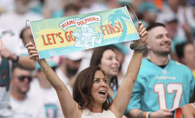 Fans cheer during the second half of an NFL football game between the Miami Dolphins and the New England Patriots Sunday, Sept. 14, 2025, in Miami Gardens, Fla. (AP Photo/Rebecca Blackwell)