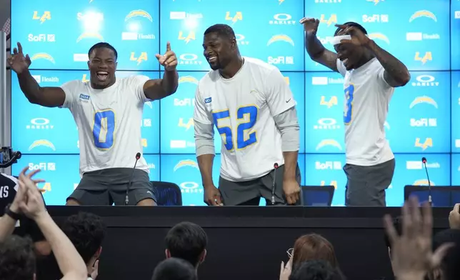 Los Angeles Chargers linebacker Daiyan Henley (0) linebacker Khalil Mack (52) and safety Derwin James Jr. joke with the press during a news conference prior to an NFL football game against the Kansas City Chiefs in Sao Paulo, Wednesday, Sept. 3, 2025. (AP Photo/Fernando Llano)