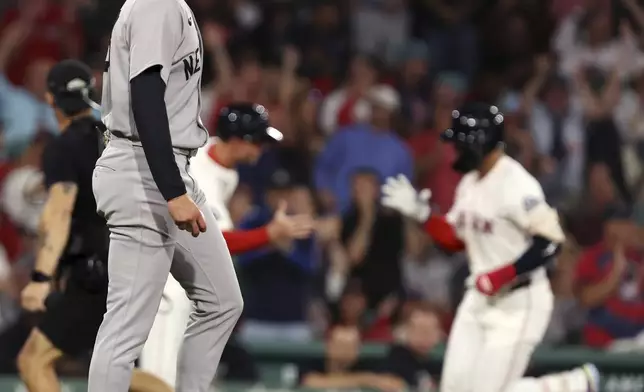 Boston Red Sox's Carlos Narvaez, back right, rounds third base after hitting a solo home run in the bottom of the first inning off New York Yankees tarting pitcher Will Warren, front left, in the first inning of a baseball game Sunday, Sept. 14, 2025, in Boston. (AP Photo/Jim Davis)