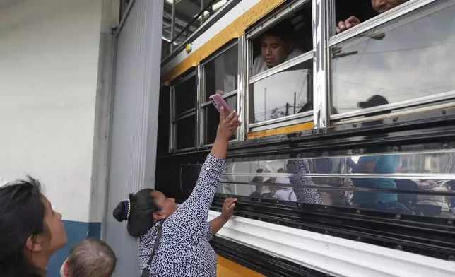 A woman asks a migrant deported from the United States if he is able to identify her relative, a migrant, outside La Aurora International Airport, in Guatemala City, Sunday, Aug. 31, 2025. (AP Photo/Moises Castillo)