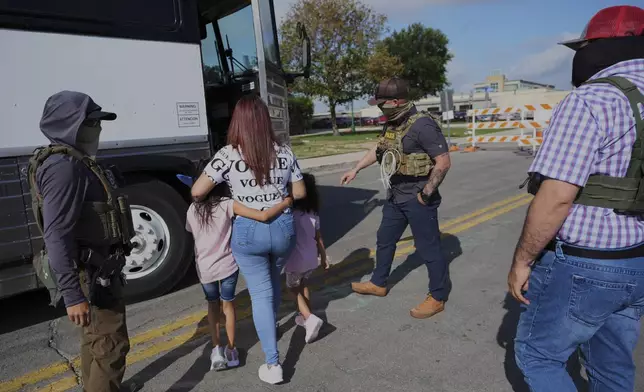 FILE - A woman from Peru and her children are detained and escorted to a bus by federal agents following an appearance at immigration court, Monday, June 23, 2025, in San Antonio. (AP Photo/Eric Gay, file)