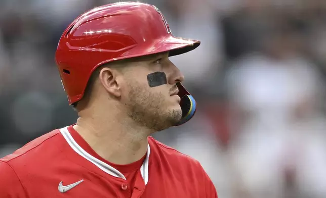 Los Angeles Angels designated hitter Mike Trout walks to first bases after his bat made contact with the glove of Colorado Rockies catcher Hunter Goodman, who was called for interference in the first inning on Saturday, Sept. 20, 2025, in Denver. (AP Photo/RJ Sangosti)